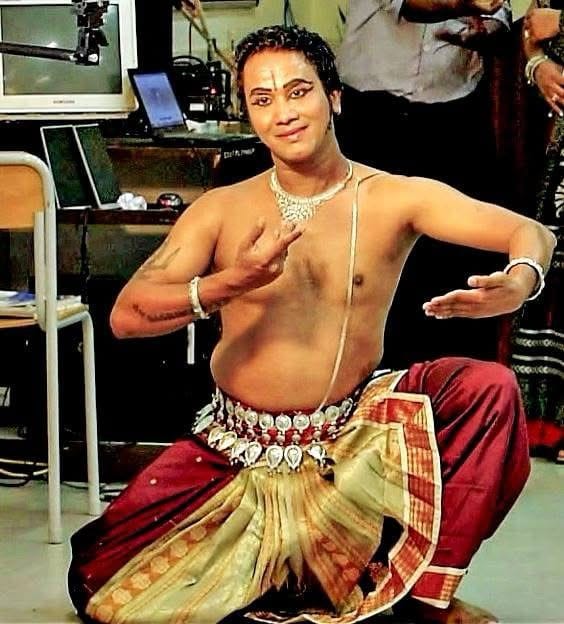 A solo Odissi Indian classical dancer performing with expressive hand gestures and graceful posture, wearing vibrant traditional costume.