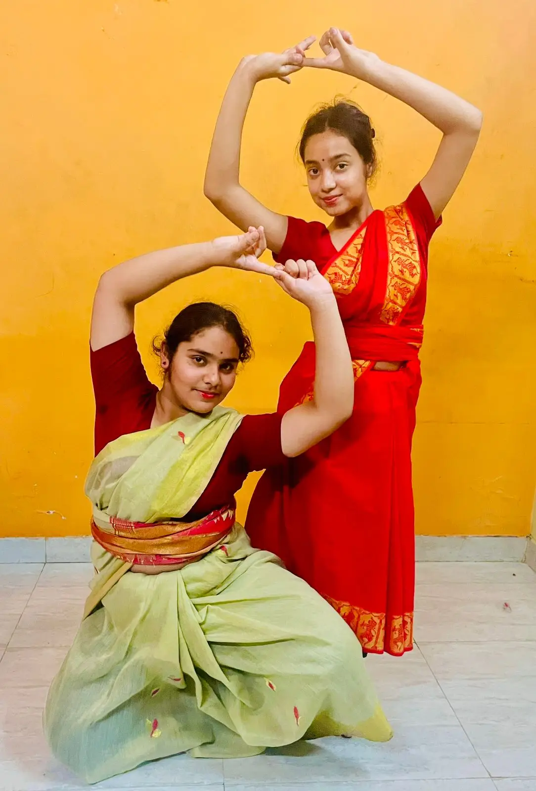 A dedicated dance student practicing graceful movements in a simple traditional cotton costume used for training sessions.