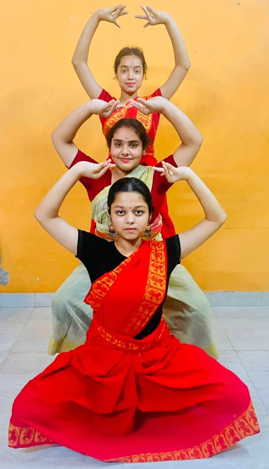 A dedicated Odissi dance student practicing graceful movements in a simple traditional cotton costume used for training sessions.